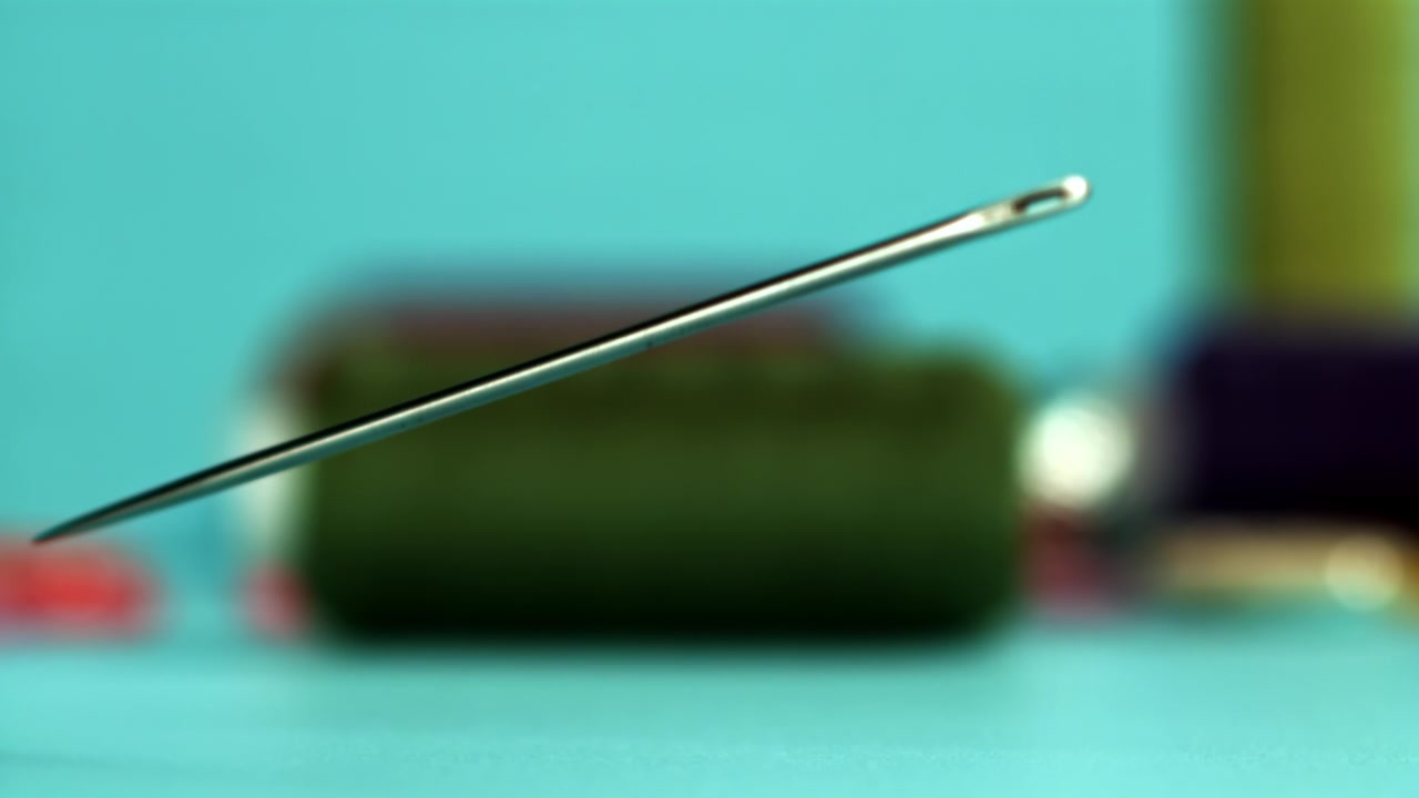 Macro Shot of a Sewing Needle Falling in Slow Motion
