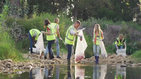 adulto medio con chaleco amarillo voluntario durante el día de limpieza del río