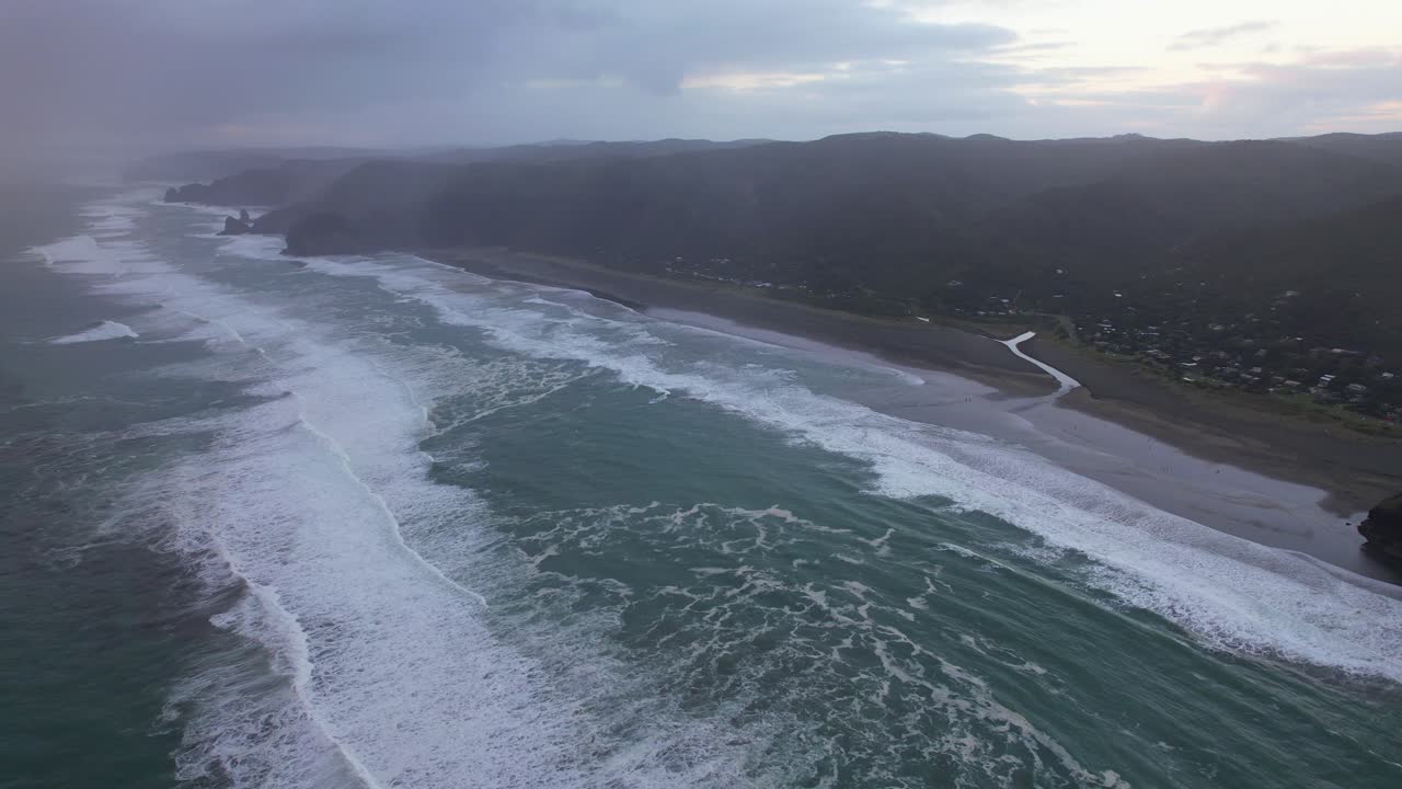 olas en la costa de piha con la roca del león en las cordilleras de waitakere parque regional, auckland, isla del norte, nueva zelanda