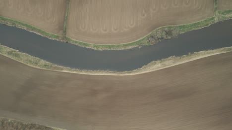 bird's eye view of river slaney surrounded by agricultural fields in county wexford, ireland - drone shot