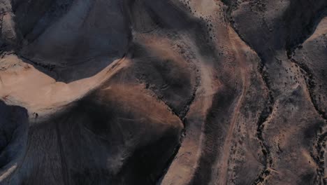 Toma-De-Inclinación-Cinematográfica-De-Drones-De-Un-Desierto-Monta,-Rayos-De-Luz,-Aspecto-De-Parque-Jurásico,-Cielo-Azul