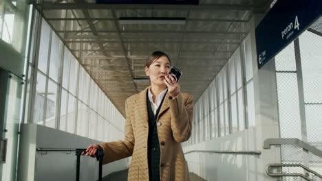 businesswoman talking on phone at train station