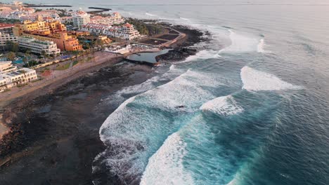 Aerial-view-of-a-tourist-resort-on-a-beach-at-sunset