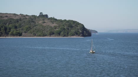 A-Small-Sail-Boat-Drifting-on-the-Sea-on-a-Calm-Sunny-Day