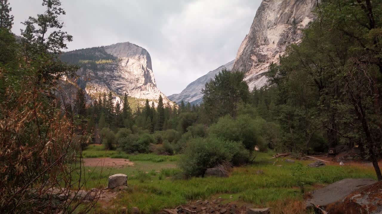 Barrido de cámara desde Half Dome hacia el lecho seco de un lago en verano