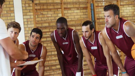 entrenador explicando el plan de juego a los jugadores de baloncesto