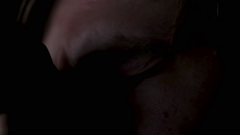 close-up of a person wearing glasses in a dark room