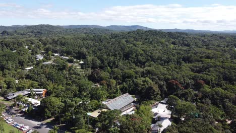 drone descending over a tropical rainforest in to a small mountain village in north queensland, australia