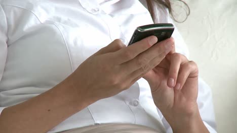 mujer encantadora enviando un mensaje de texto en el sofá