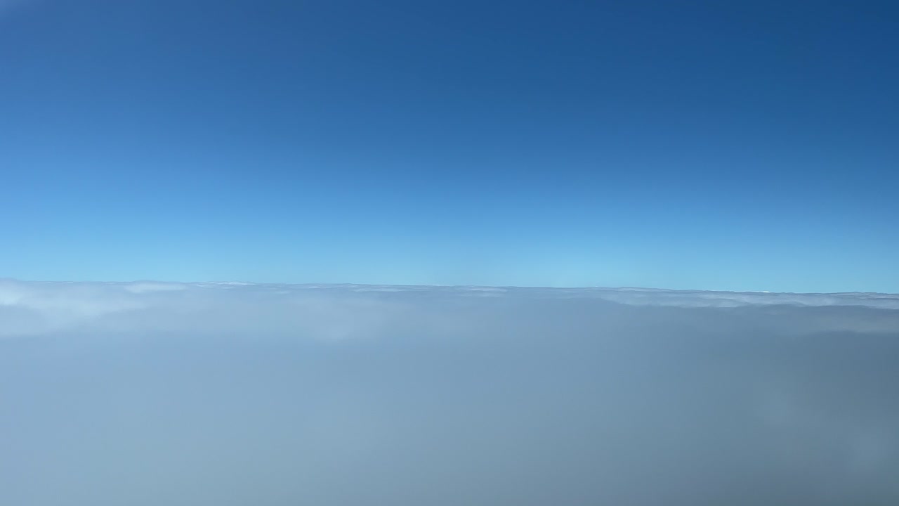 A pilot&rsquo;s perspective recorded from a jet cockpit flying just some layers of clouds during the descend to Funchal airpor, Madeira