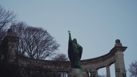 saint gellert monument at the gellert hill in budapest hungary with bare trees and antique columns in the background - tilt down pan shot