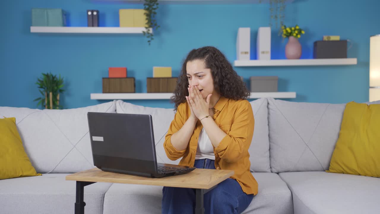 mujer joven mirando la computadora portátil con asombro.