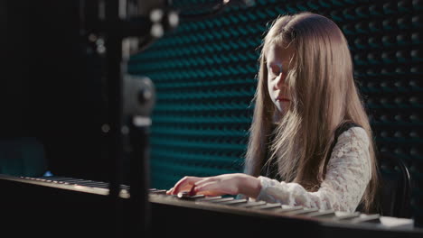 young girl playing piano in a recording studio