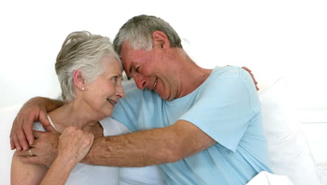 Senior-couple-embracing-on-bed