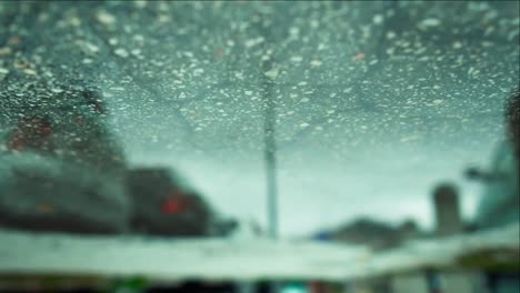 Slow-motion-tiny-rain-drops-captured-at-the-water-surface-on-the-street