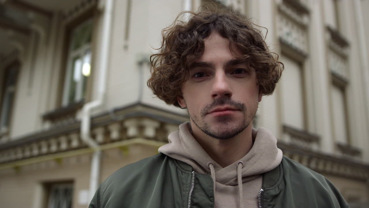 hombre enfocado mirando la cámara en la calle. chico genial posando en el fondo de la ciudad.