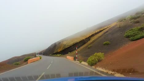 driver pov on an empty mountain road envailed in fog, teide national park, canary islands, tenerife, spain