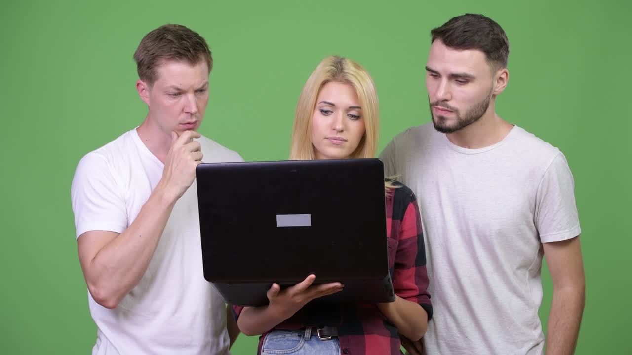 Three young friends using laptop together