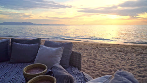 pillows on outdoor patio deck chair on beach with sunset times background