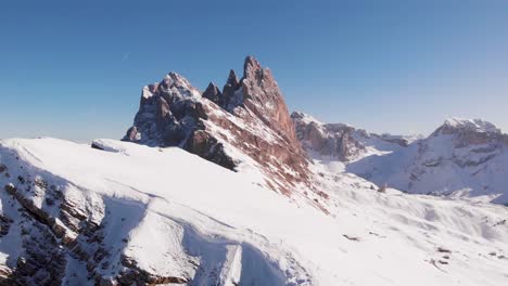 dolomites mountain peak covered in snow on a sunny day, aerial paning