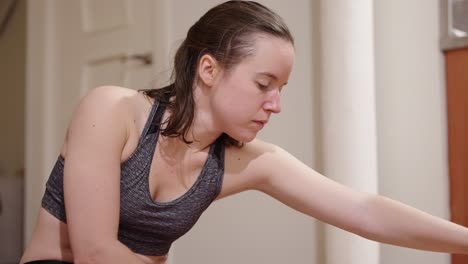 young woman stretching during her daily workout routine at home