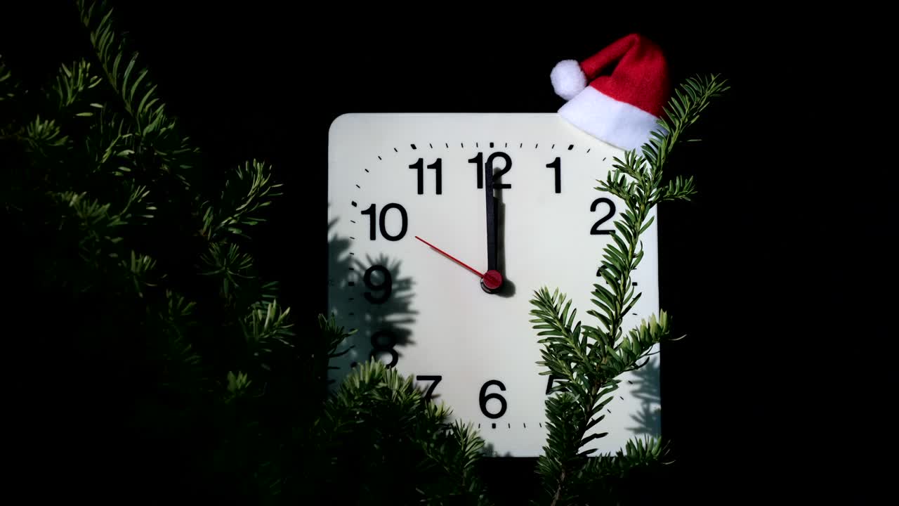 reloj en ramas de abeto de año nuevo en fondo negro. la manilla de segundos se mueve en círculo de reloj mecánico y muestra las doce en punto a medianoche y víspera de navidad. concepto de vacaciones, lapso de tiempo, primer plano, primer plano