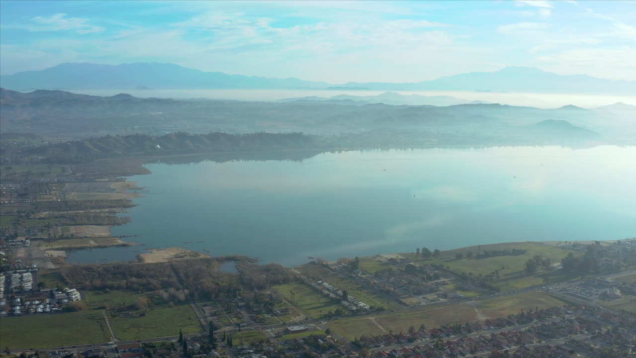 Vista aerea di un lago circondato da montagne e aree residenziali