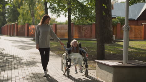 caring mother holds hand of daughter with spinal cord injury