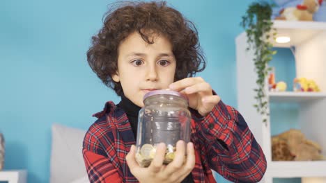 Boy-throws-money-into-piggy-bank-and-is-happy.