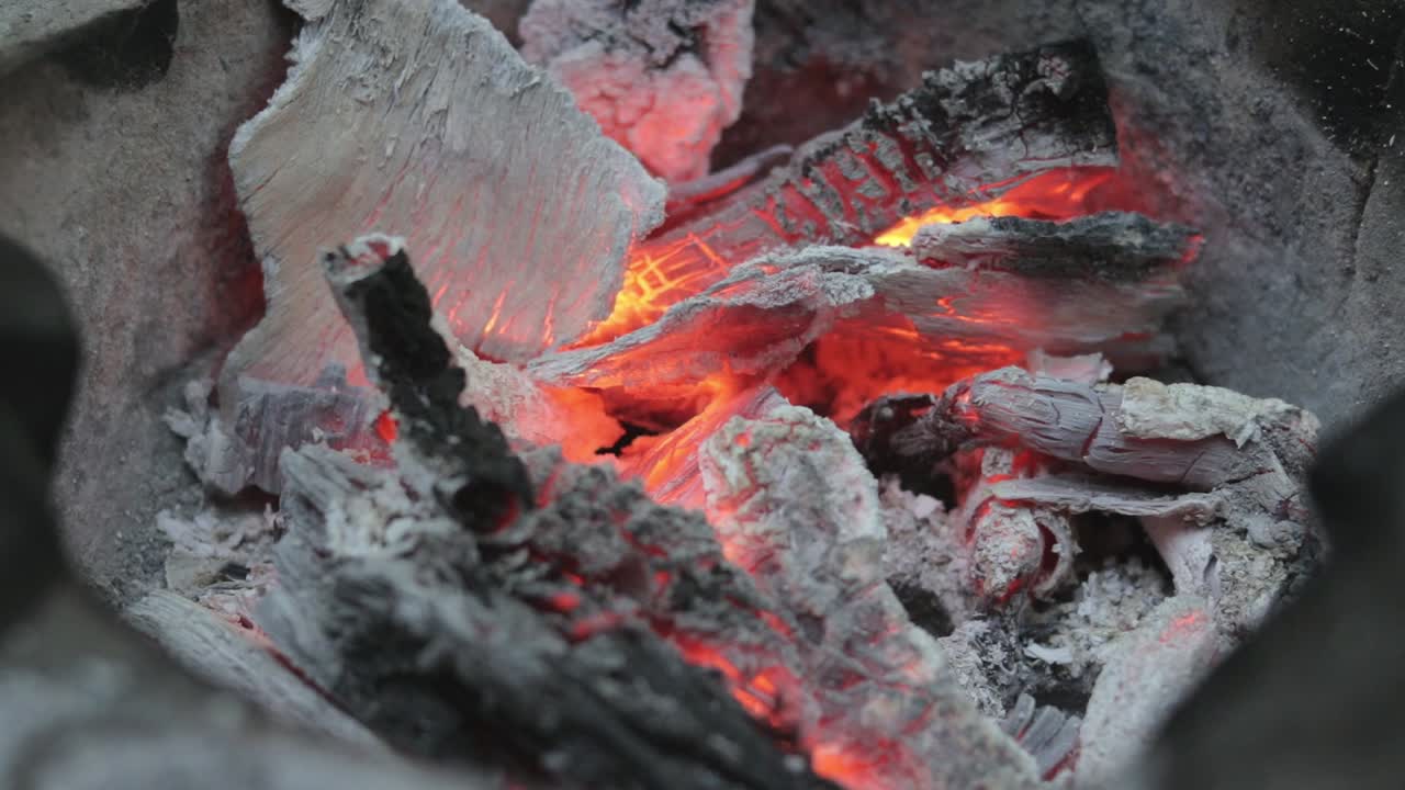 Static shot of bonfire embers slowly burning out the charcoal, close up shot