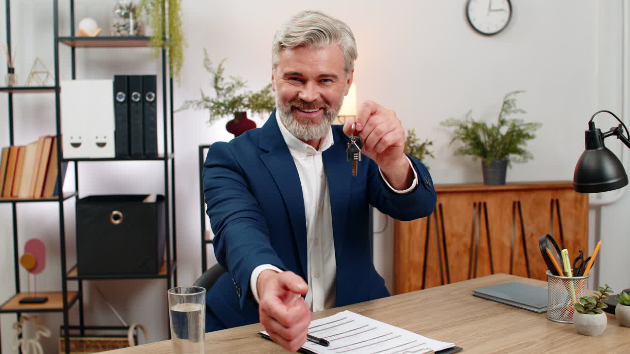 Middleaged businessman signs lease holds apartment keys smiles shakes agent hand marking milestone