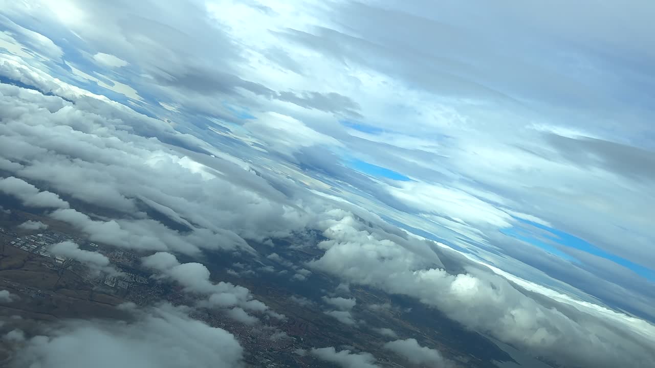 POV flying through a multilayered sky full of cumulus and stratocumulus clouds, doing a left turn over a mountainous area