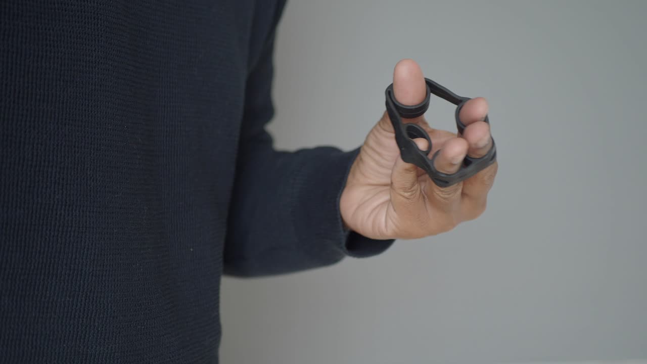 Person Using Finger Exerciser for Hand Strength Training