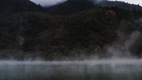 zoom in on steam rising from geothermal lake in volcanic region, new zealand, north island