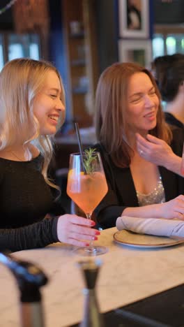 friends engaging in lively conversation while sipping on vibrant cocktails in an upscale and stylish bar setting