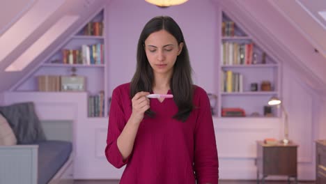 una chica india estresada comprobando una prueba de embarazo.