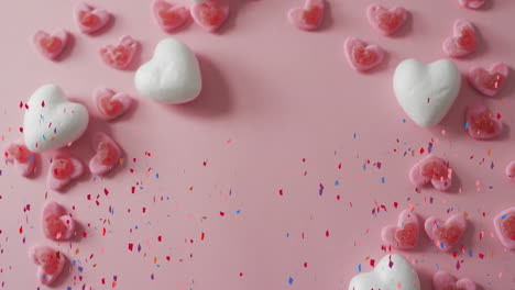 hearts and confetti animation over pink background with scattered heart decorations