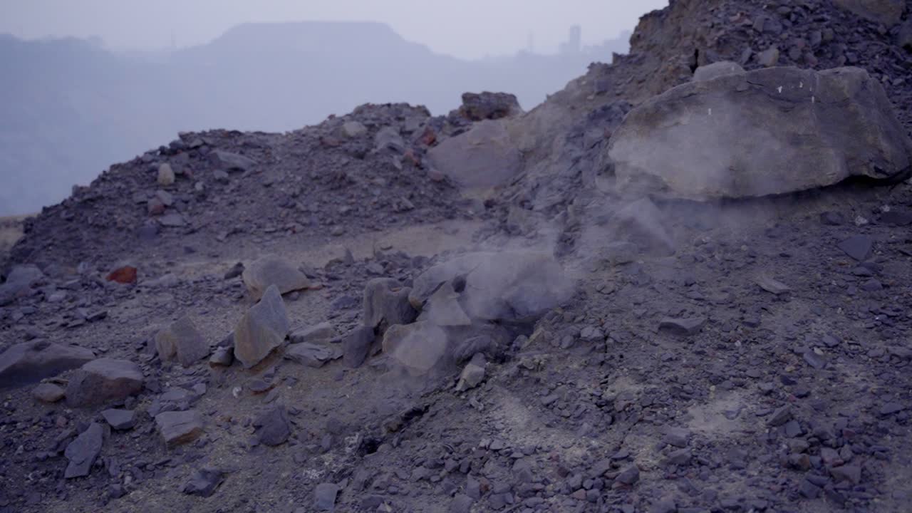 Jharia Coal mine with smoke and burning embers coming from the underground coal field fire