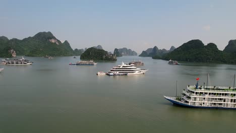 aerial zoom out of traditional vietnamese cruise ship traveling with tourists in ha long bay vietnam at sunrise