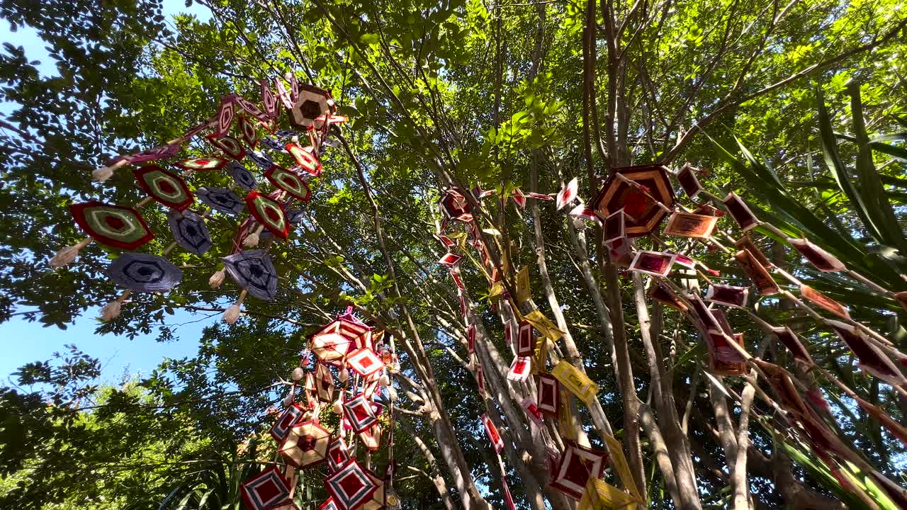 móviles vibrantes se balancean entre los árboles verdes y exuberantes