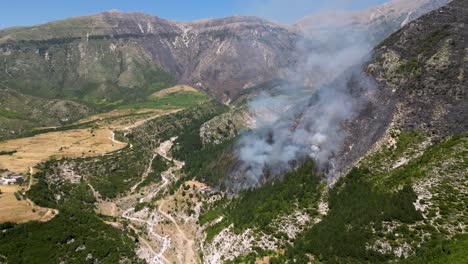wildfires burning the forest at the foot of the mountain and closing in on the village nearby