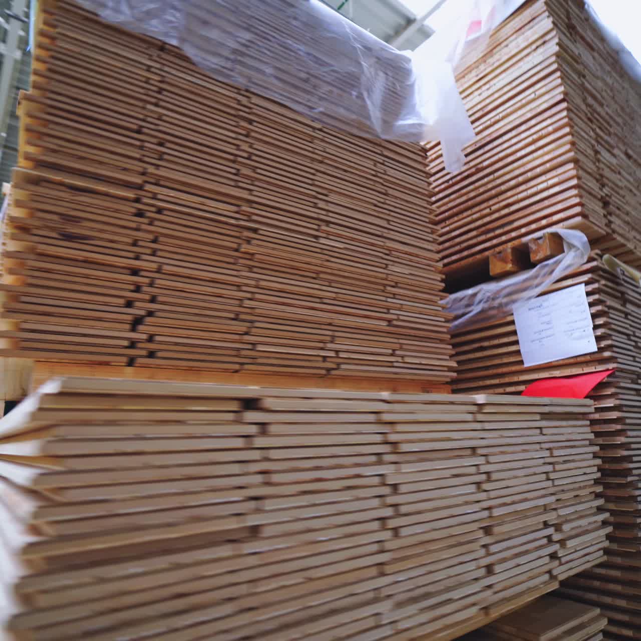 Piles of laminate floor panels in the workshop. Factory for the production of parquet board. Modern industrial woodworking factory.