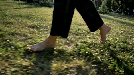 legs of women walk on grass in park in daytime in summer, healthy lifestyle