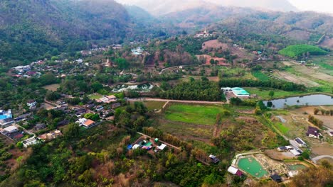 drone above chiang dao in chiang mai province, thailand green valley with rice field and resort for weekend holiday