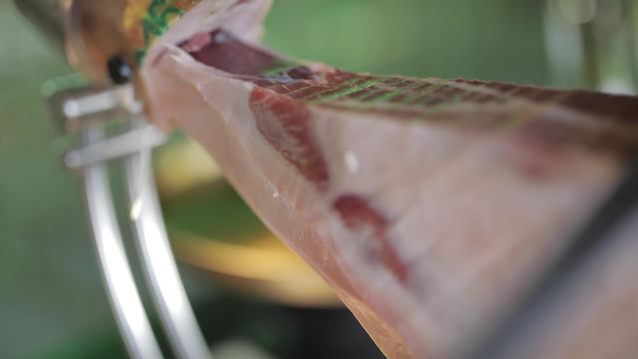 cocinero de cultivos cortando un pedazo de carne de jamón
