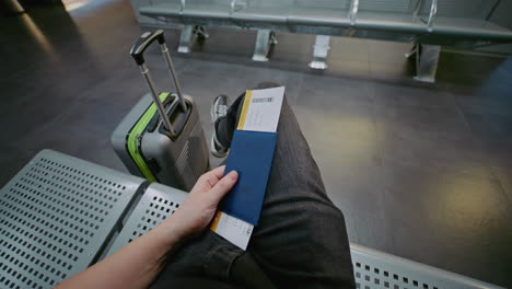 Person Waiting at Airport with Passport and Boarding Pass