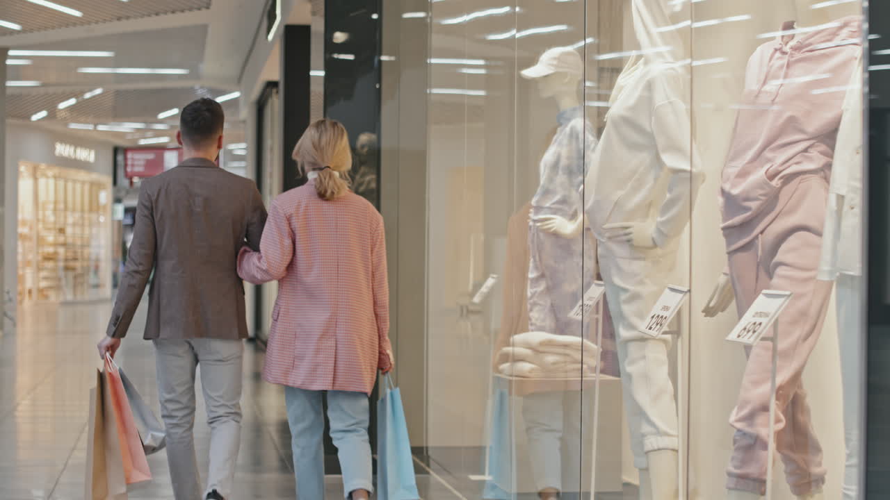 Young Smart Couple Walking Along Big Shopping Centre