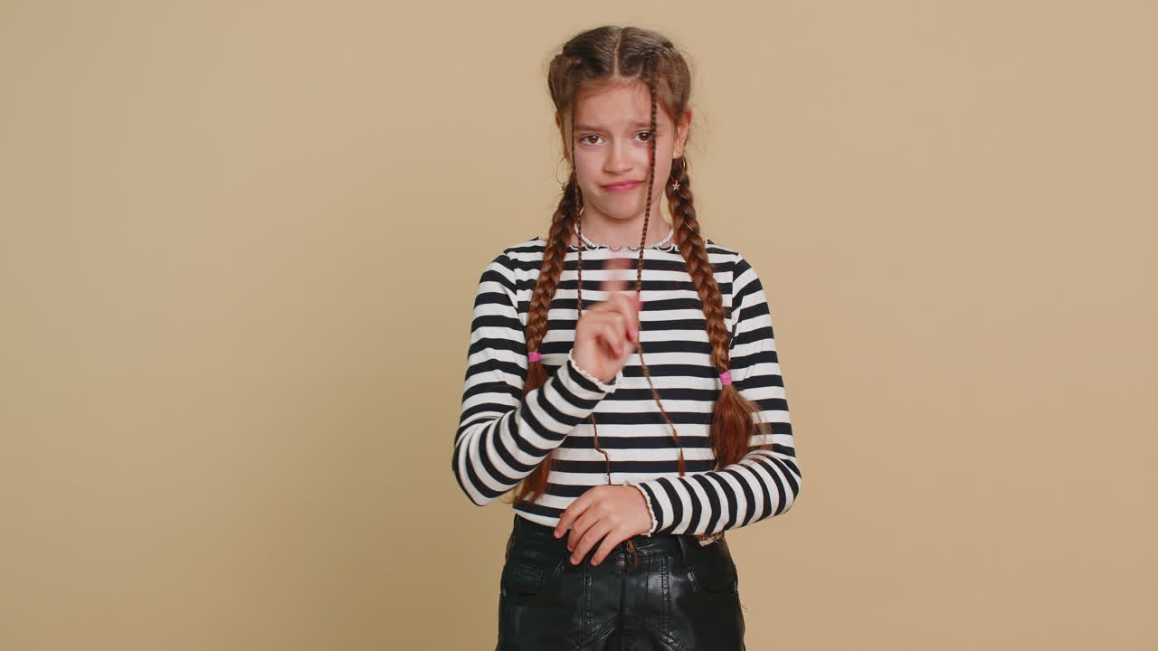 Frightened child girl closing mouth with hands refusing to tell terrible secret unbelievable truth