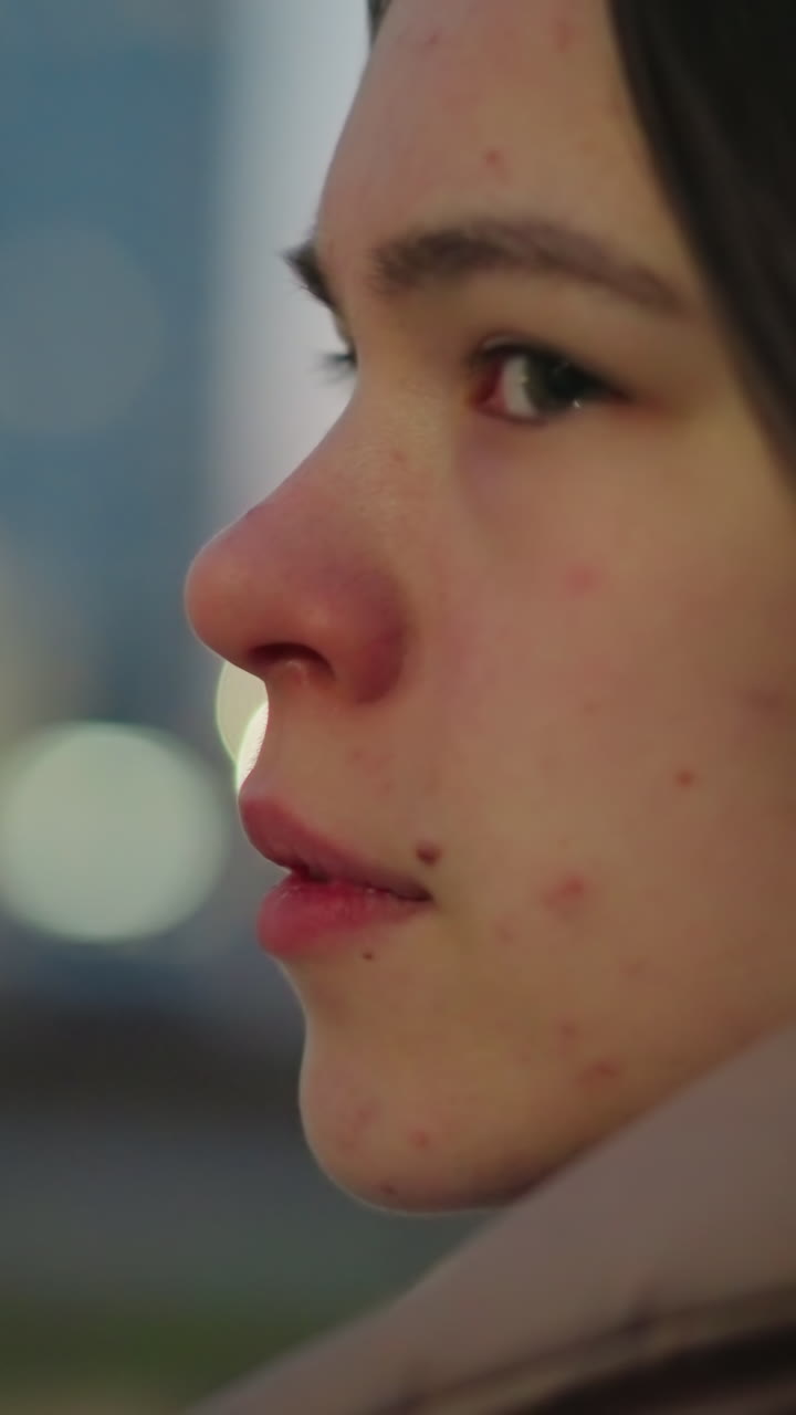 Close-up of a girl's face with a blurred background, capturing her eyes blinking. The intimate shot highlights her delicate features and adds a dynamic, natural touch to the serene ambiance