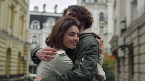 Encantadora-Pareja-Abrazándose-En-La-Calle.-Novia-Feliz-Inclinándose-Hacia-Su-Novio-Al-Aire-Libre.